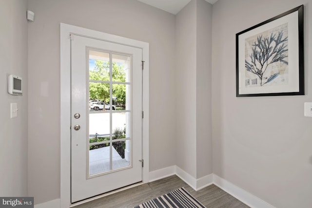 doorway to outside featuring dark wood-type flooring and baseboards