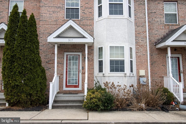 entrance to property with brick siding and stucco siding