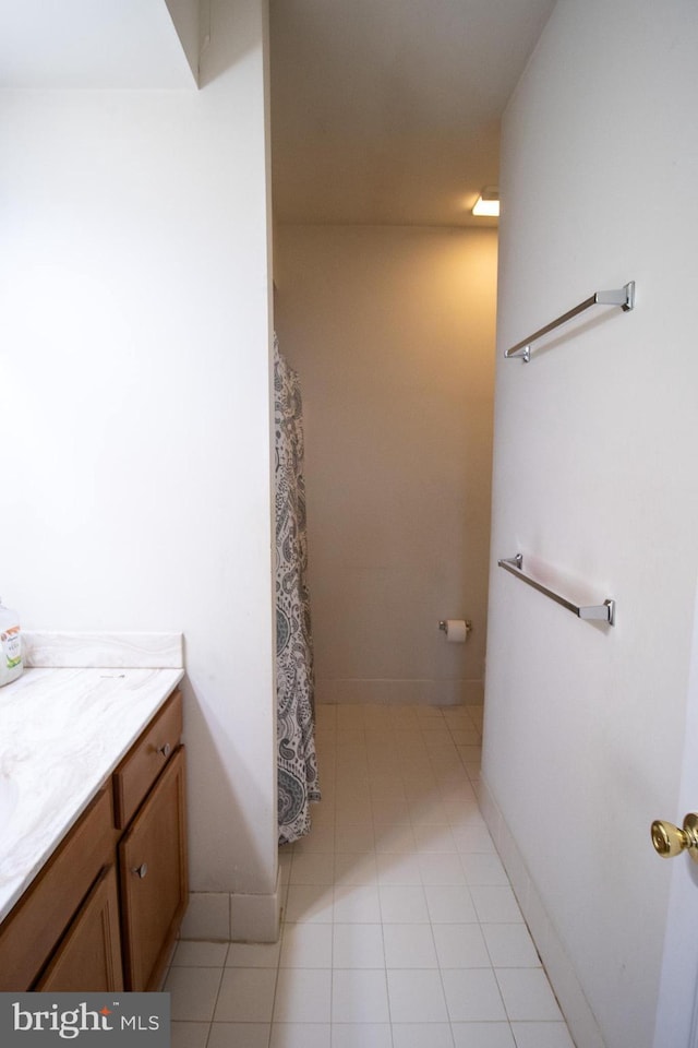 full bath featuring baseboards and vanity