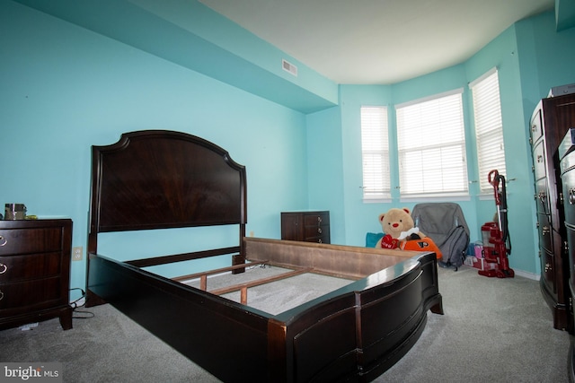 carpeted bedroom featuring visible vents