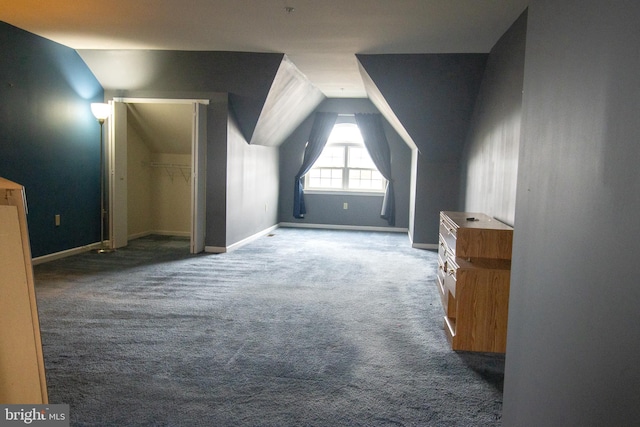 additional living space with vaulted ceiling, baseboards, and carpet floors