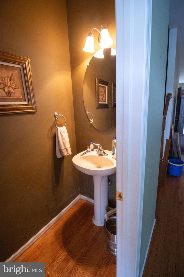 bathroom featuring a sink, baseboards, and wood finished floors