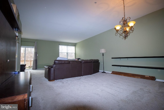 living area featuring a notable chandelier, carpet flooring, and baseboards