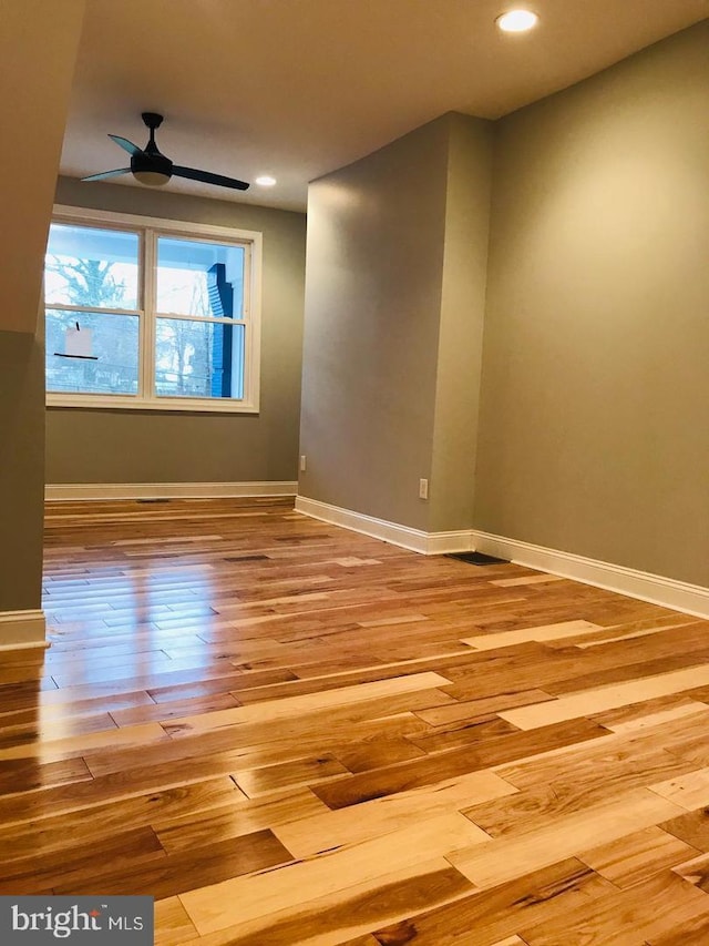 empty room featuring ceiling fan, baseboards, wood finished floors, and recessed lighting