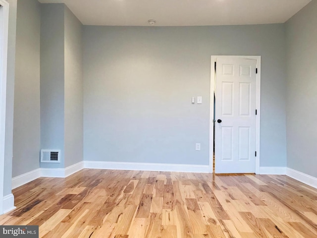 empty room with light wood-type flooring, baseboards, and visible vents