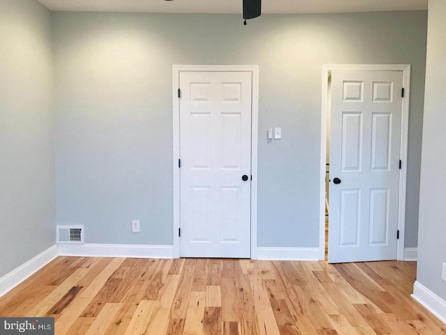 empty room with visible vents, baseboards, light wood-style floors, and ceiling fan