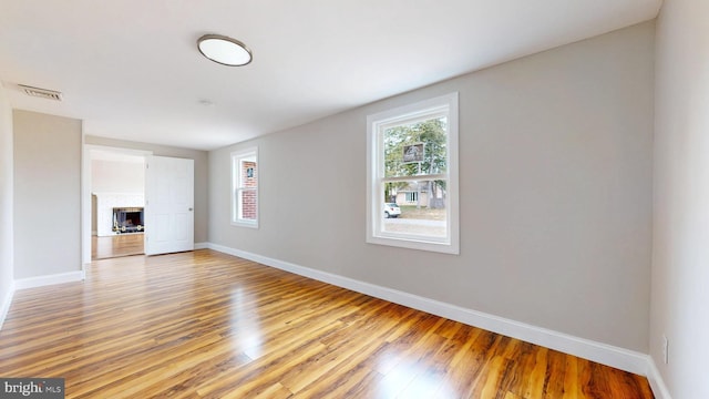 spare room featuring light wood-style flooring, baseboards, and visible vents