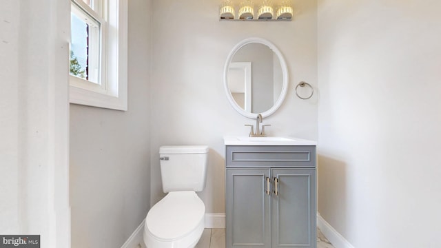 bathroom with baseboards, toilet, and vanity