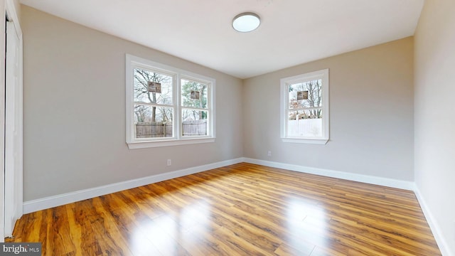 empty room featuring wood finished floors and baseboards