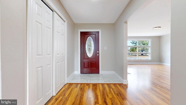 foyer featuring baseboards and wood finished floors