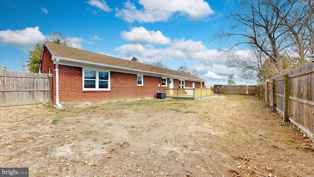 back of property featuring brick siding, central air condition unit, and a fenced backyard