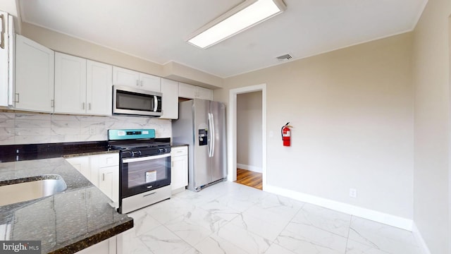 kitchen featuring visible vents, stainless steel appliances, marble finish floor, white cabinetry, and tasteful backsplash