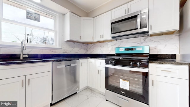 kitchen with tasteful backsplash, marble finish floor, stainless steel appliances, and a sink