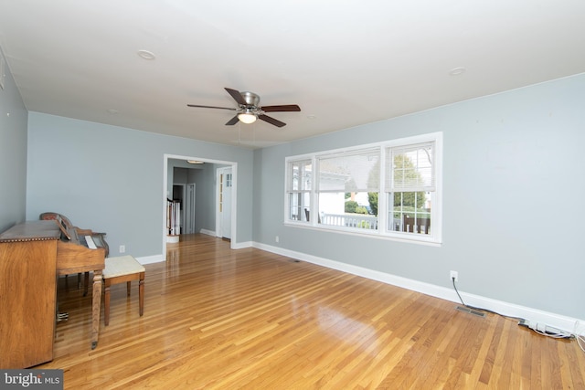 interior space featuring visible vents, light wood-style flooring, baseboards, and a ceiling fan