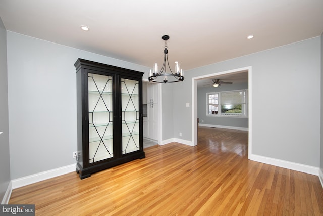 interior space featuring ceiling fan with notable chandelier, light wood-style flooring, recessed lighting, and baseboards