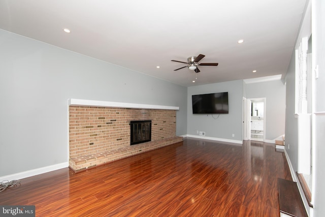 unfurnished living room featuring a fireplace, wood finished floors, baseboards, and ceiling fan