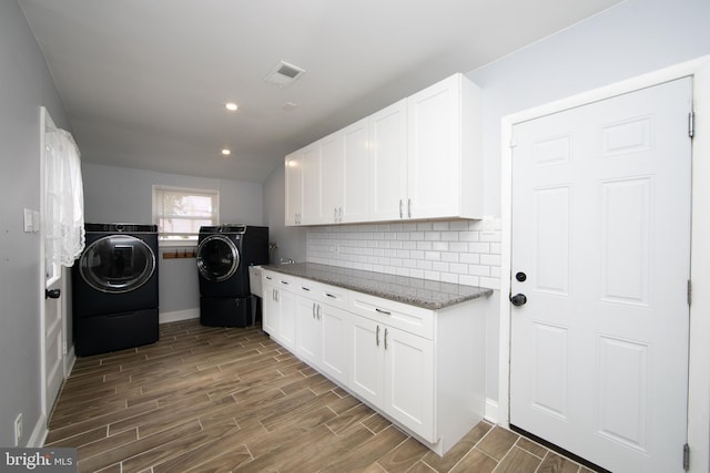 laundry room with visible vents, washer and dryer, recessed lighting, cabinet space, and wood tiled floor