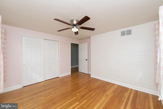 unfurnished bedroom featuring visible vents, a ceiling fan, a closet, light wood-style floors, and baseboards