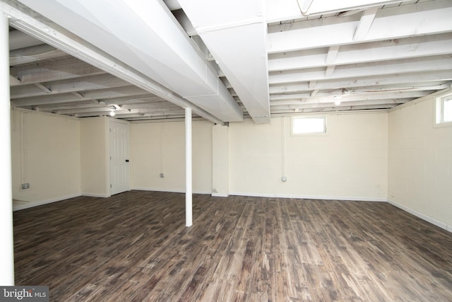 basement with concrete block wall and wood finished floors