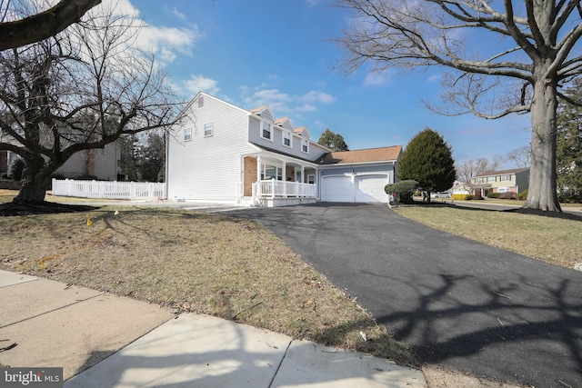 view of front of property with a porch, fence, a garage, and driveway