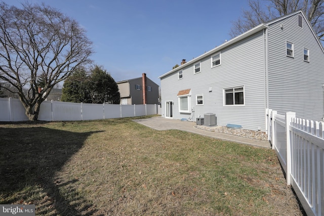 rear view of property with a patio area, a lawn, cooling unit, and a fenced backyard