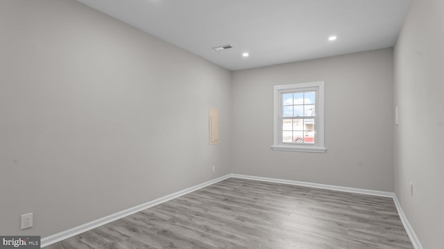 unfurnished room with visible vents, recessed lighting, wood finished floors, and baseboards