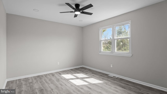 unfurnished room with visible vents, ceiling fan, baseboards, and wood finished floors