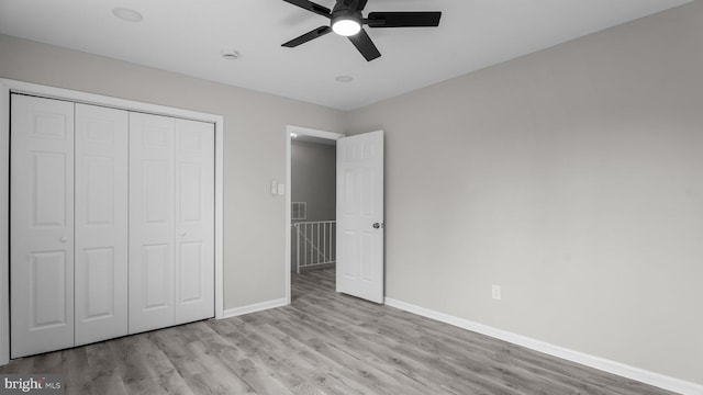 unfurnished bedroom featuring visible vents, baseboards, light wood finished floors, ceiling fan, and a closet