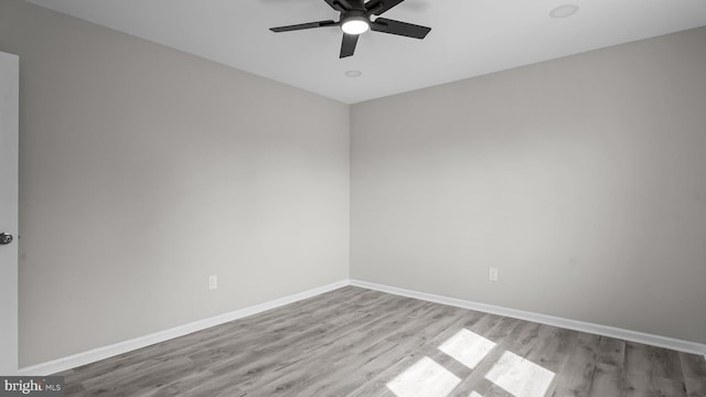 unfurnished room with baseboards, wood finished floors, and ceiling fan