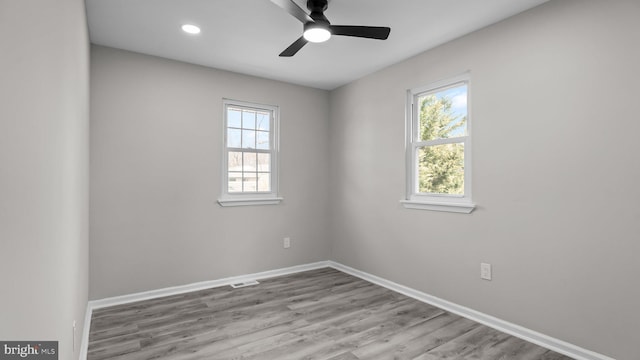 unfurnished room with baseboards, a healthy amount of sunlight, wood finished floors, and a ceiling fan