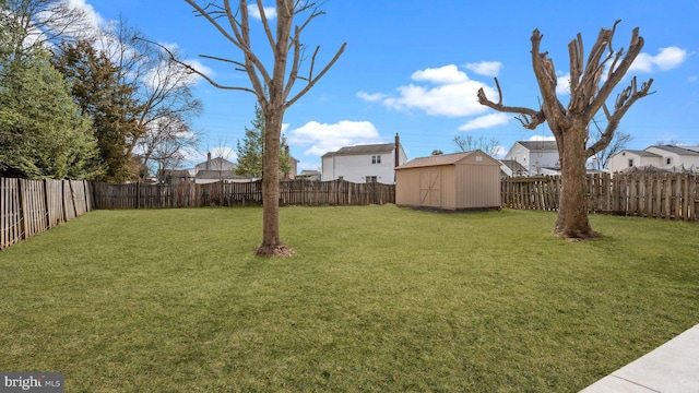 view of yard featuring a storage shed, an outdoor structure, and a fenced backyard