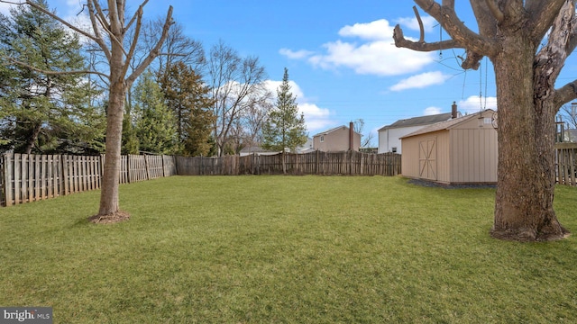 view of yard with an outdoor structure, a storage unit, and a fenced backyard