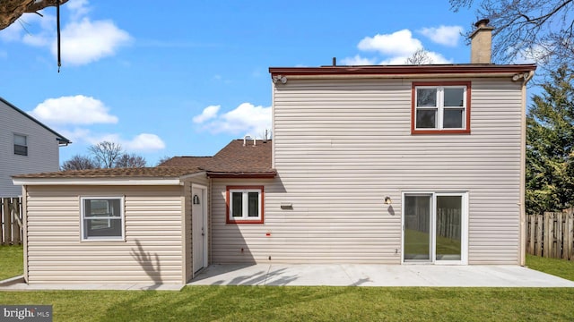 back of property featuring a yard, a patio area, a chimney, and fence