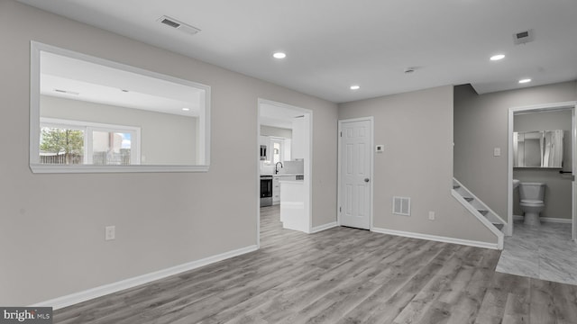 unfurnished living room with recessed lighting, visible vents, baseboards, and wood finished floors