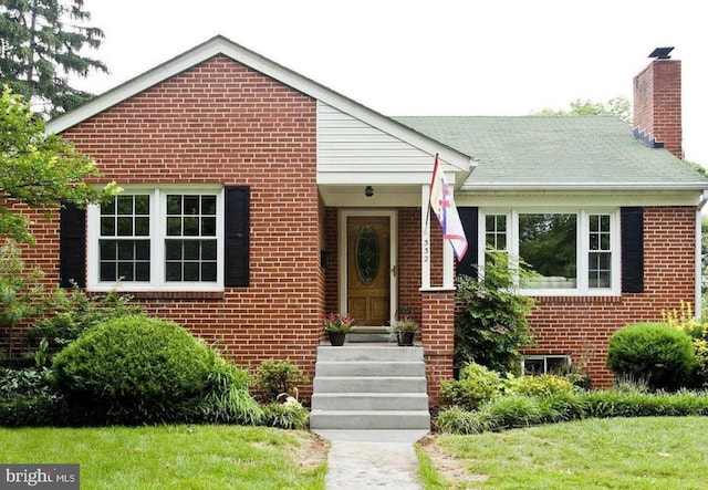 view of front of house with brick siding and a chimney