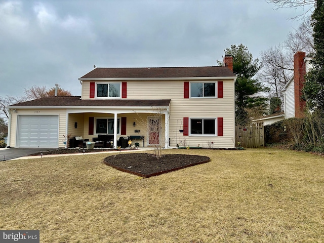 traditional-style home featuring a front lawn, an attached garage, fence, and a chimney