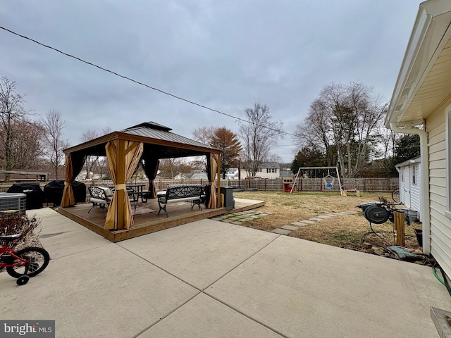 view of patio / terrace with a gazebo, grilling area, a fenced backyard, and a playground