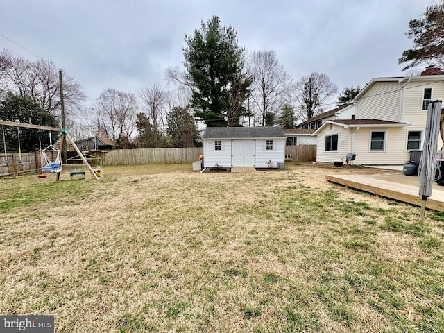 view of yard featuring an outbuilding, a fenced backyard, and a playground