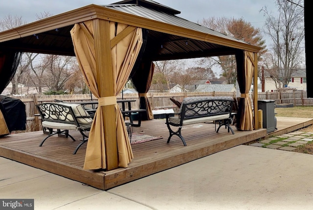 view of community featuring a gazebo, a wooden deck, and a fenced backyard