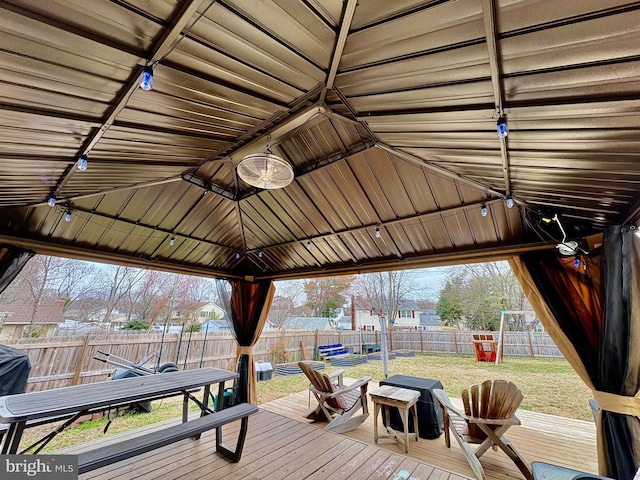 wooden terrace featuring a gazebo, a lawn, and a fenced backyard