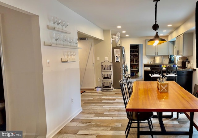 dining space featuring recessed lighting, light wood-type flooring, baseboards, and a dry bar