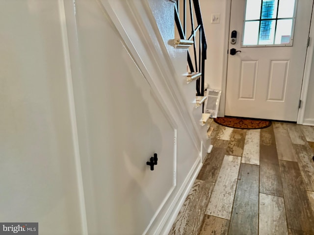 doorway with hardwood / wood-style floors and stairs