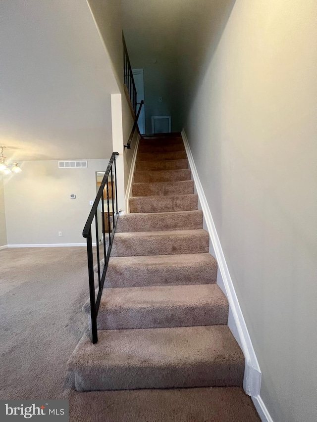 stairs with visible vents, baseboards, and carpet