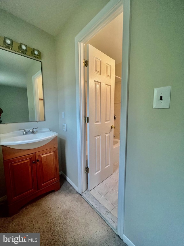 bathroom with baseboards, shower / washtub combination, and vanity