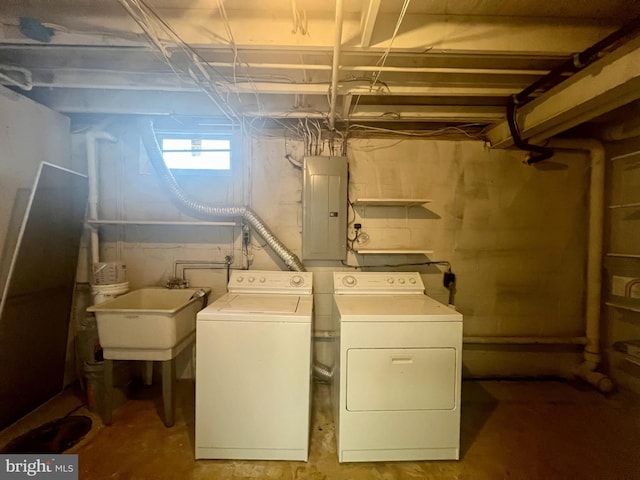 laundry room featuring washer and dryer, laundry area, electric panel, and a sink