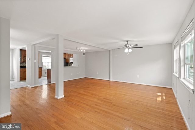 8042 Saint Annes Ct, Alexandria, VA 22309 - unfurnished living room with a ceiling fan, healthy amount of natural light, light wood finished floors, and baseboards