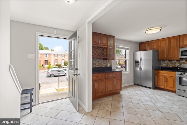 8042 Saint Annes Ct, Alexandria, VA 22309 - kitchen with stainless steel appliances, dark countertops, brown cabinets, and decorative backsplash