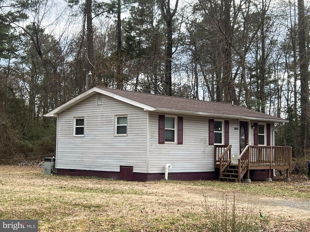 view of front facade featuring crawl space, a deck, a front yard, and a shingled roof