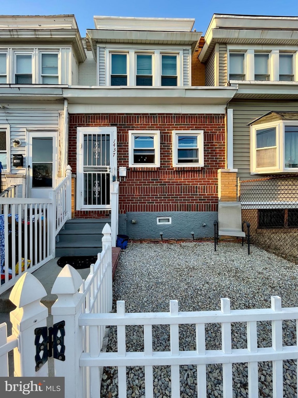 multi unit property with brick siding, a fenced front yard, and crawl space