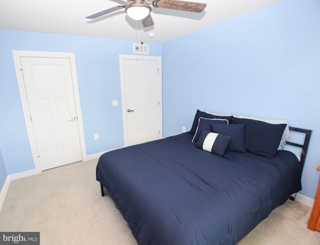 bedroom featuring ceiling fan, light colored carpet, visible vents, and baseboards